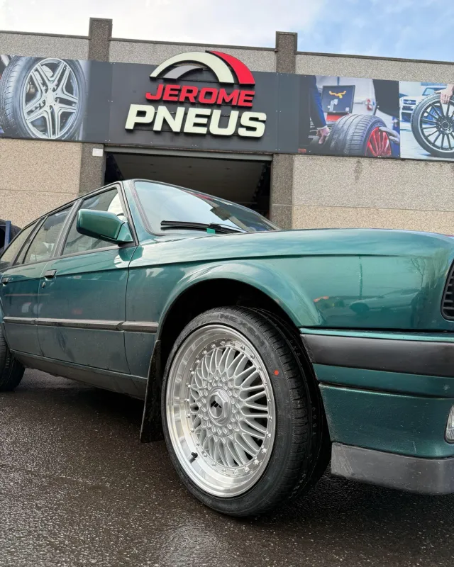 BMW E30 et jantes alu devant le garage Jérôme-Pneus à Gosselies